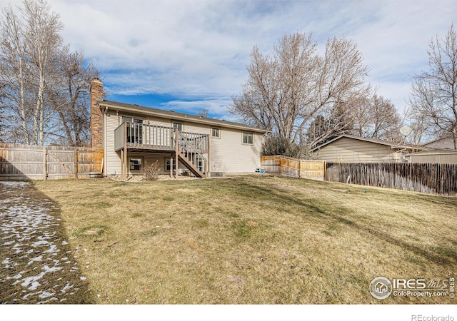 rear view of property featuring a lawn and a deck