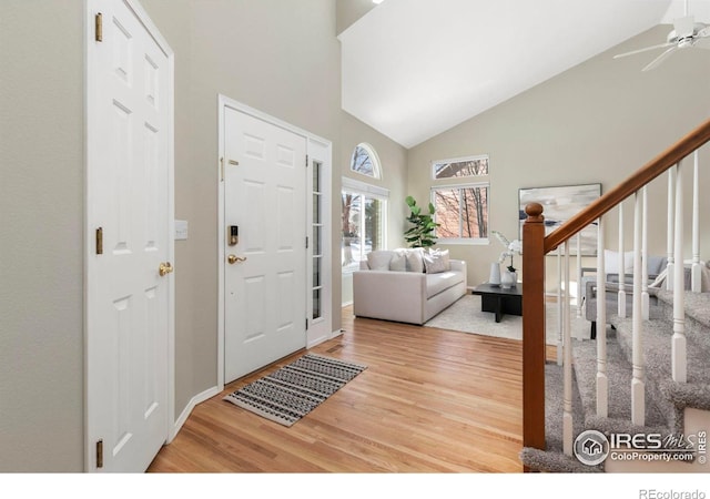 foyer with high vaulted ceiling, hardwood / wood-style floors, and ceiling fan