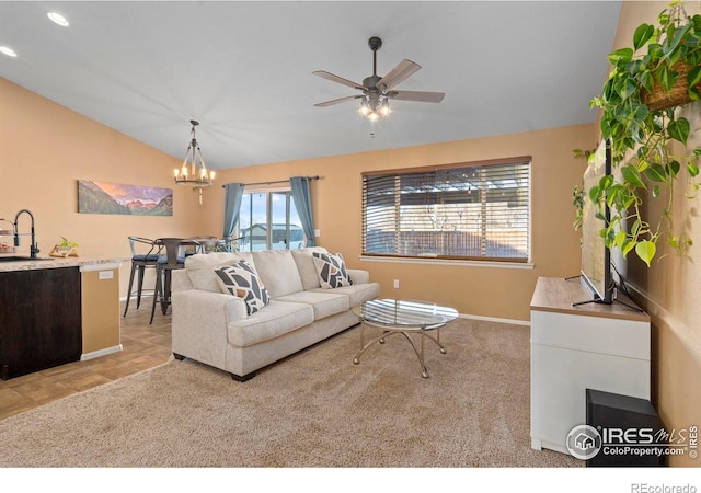 living room with lofted ceiling, sink, and ceiling fan with notable chandelier