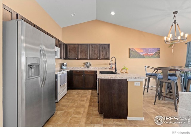 kitchen featuring lofted ceiling, sink, white appliances, hanging light fixtures, and dark brown cabinets