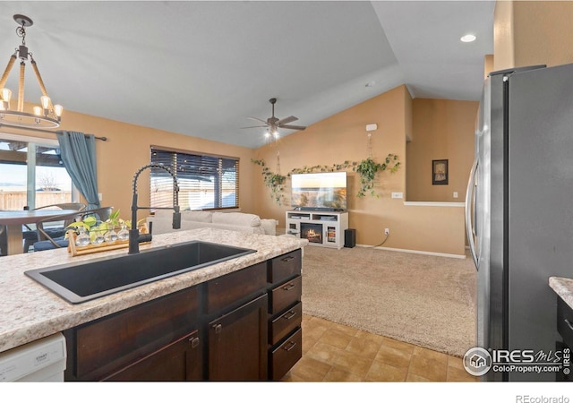 kitchen with lofted ceiling, sink, stainless steel fridge, hanging light fixtures, and white dishwasher