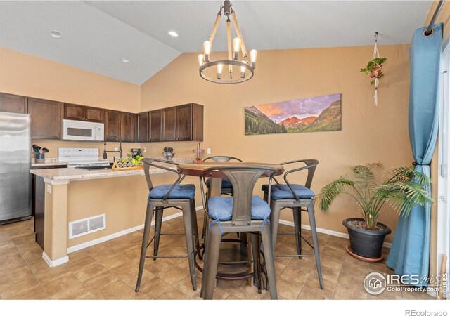 tiled dining area with an inviting chandelier and high vaulted ceiling