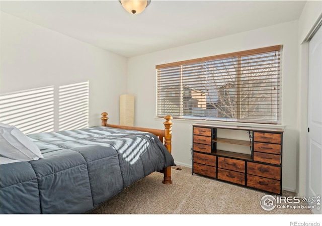 bedroom with light carpet and a closet