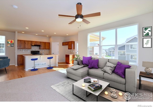 living room featuring ceiling fan and light wood-type flooring