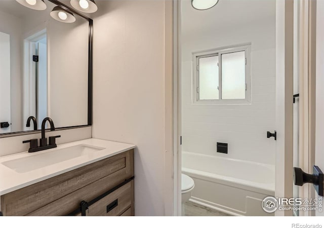 bathroom with bathtub / shower combination, vanity, and toilet