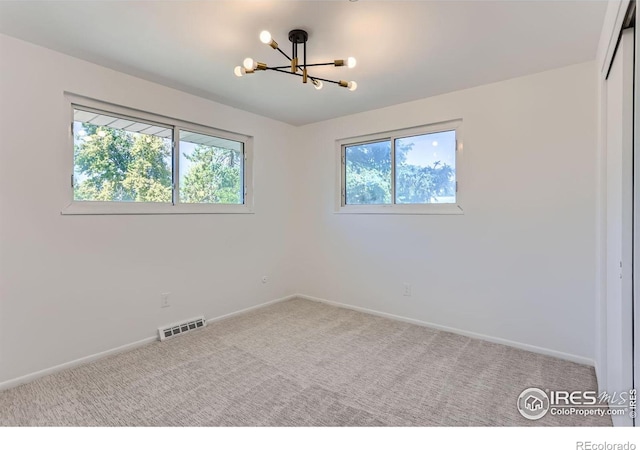 unfurnished bedroom with a chandelier, visible vents, carpet flooring, and multiple windows