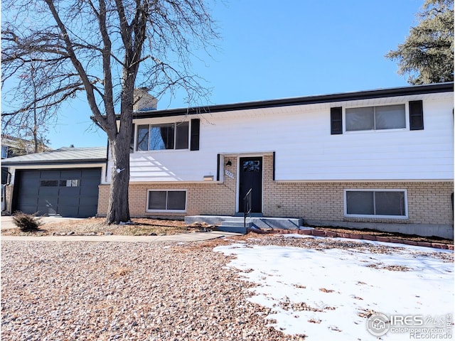 bi-level home featuring brick siding and an attached garage