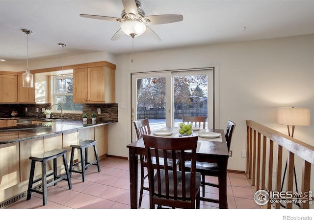 dining area with ceiling fan, sink, and light tile patterned floors