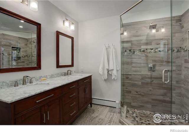 bathroom featuring a baseboard radiator, vanity, and a shower with shower door