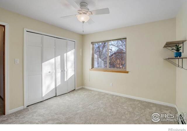 unfurnished bedroom with light carpet, a closet, and ceiling fan