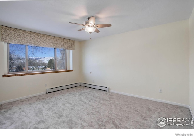 carpeted spare room with ceiling fan and a baseboard radiator