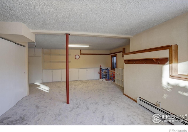 basement with a baseboard heating unit, light carpet, and a textured ceiling