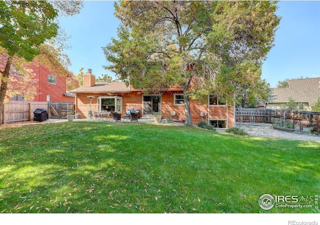 rear view of property with a yard and a patio area