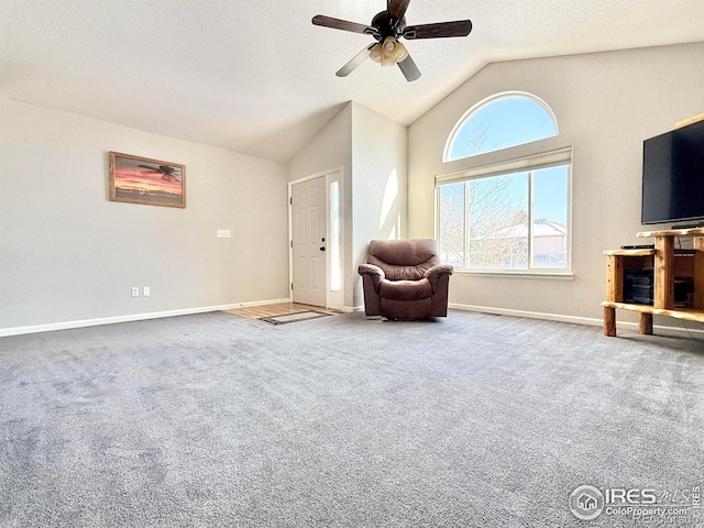 sitting room with ceiling fan, lofted ceiling, and carpet flooring