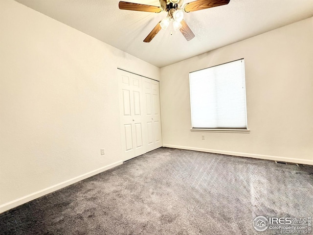 unfurnished bedroom featuring carpet floors, a closet, and ceiling fan