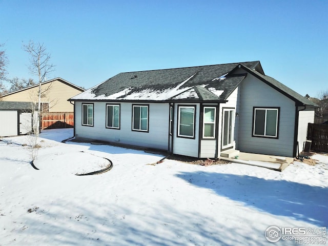 view of snow covered back of property