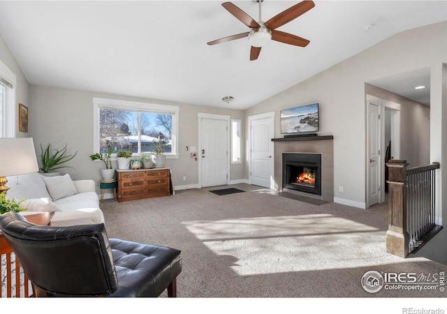 living room featuring lofted ceiling, carpet flooring, and a tile fireplace