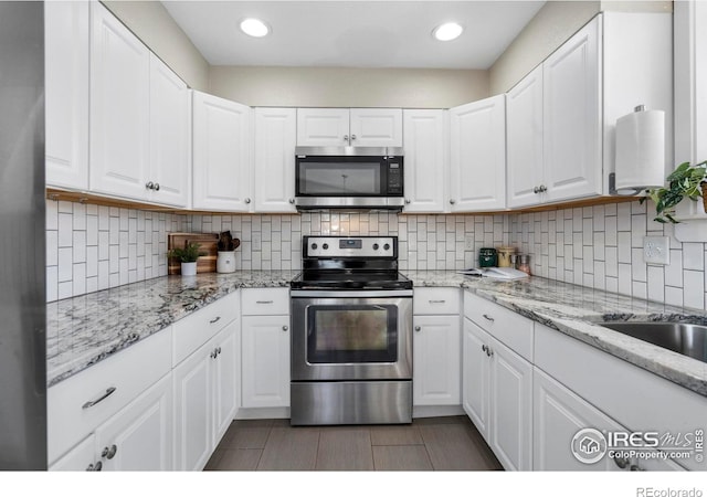 kitchen featuring white cabinetry, sink, decorative backsplash, and appliances with stainless steel finishes