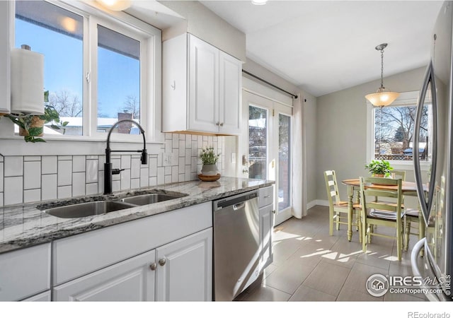 kitchen featuring stainless steel appliances, white cabinetry, pendant lighting, and decorative backsplash