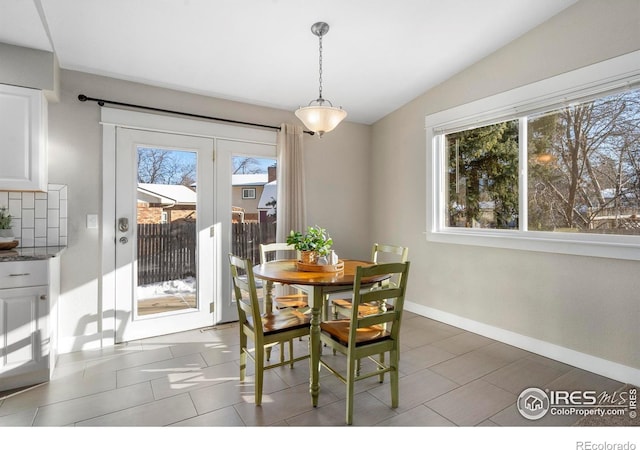 dining room featuring lofted ceiling and dark tile patterned flooring