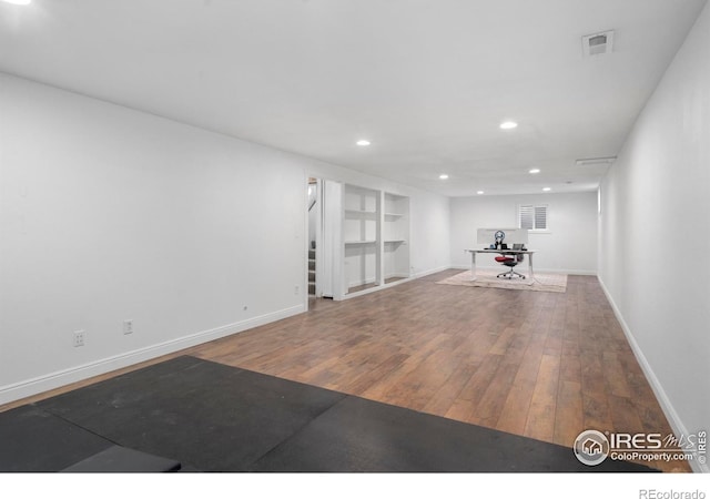 workout area with wood-type flooring and built in features