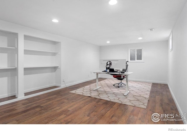 office area with hardwood / wood-style floors and built in shelves