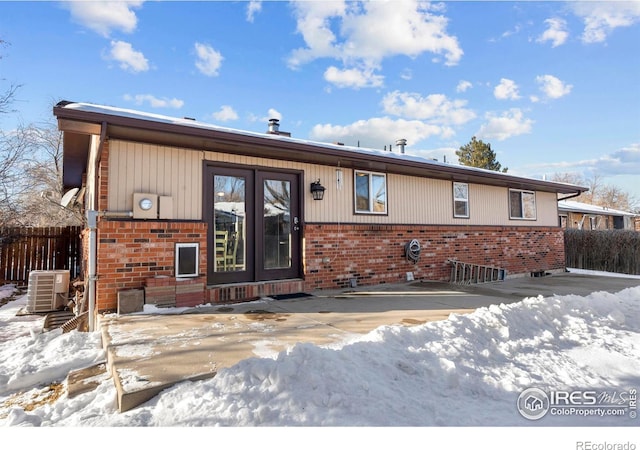 snow covered property featuring central AC