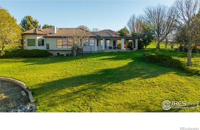 exterior space featuring a front lawn and a pergola