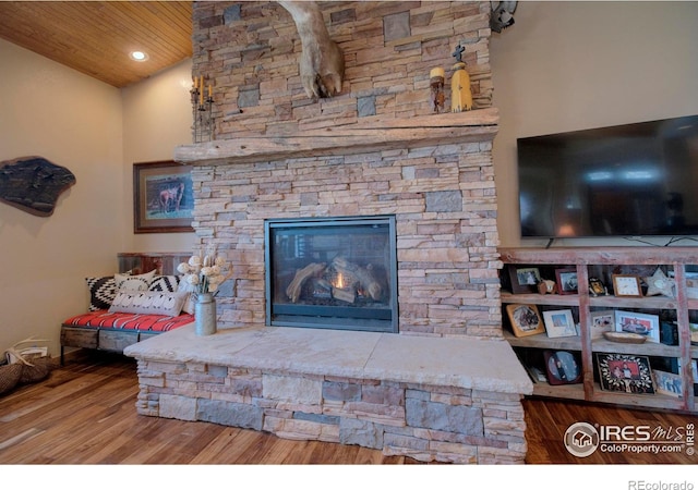 living room with lofted ceiling, wood ceiling, a fireplace, and hardwood / wood-style flooring