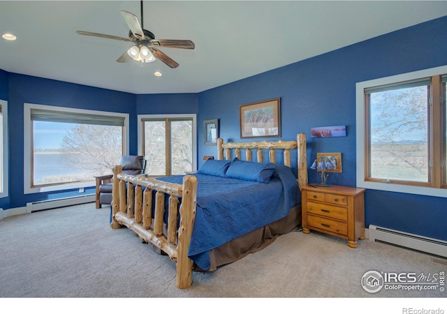 carpeted bedroom with a baseboard radiator and ceiling fan