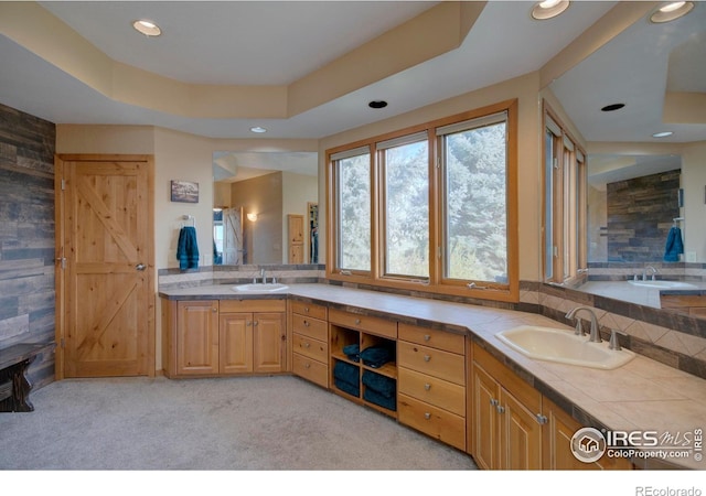 bathroom with a raised ceiling and vanity