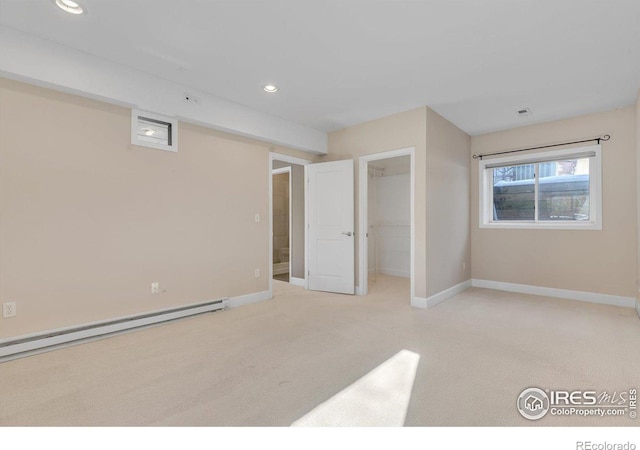 unfurnished bedroom with baseboards, baseboard heating, and light colored carpet