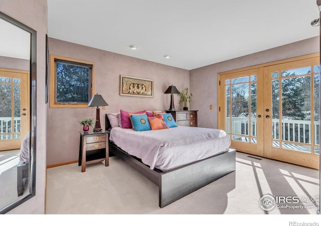 bedroom featuring light carpet, access to exterior, multiple windows, and french doors