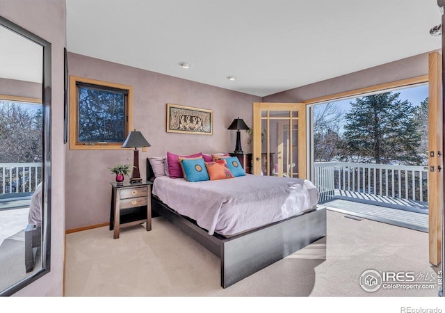 bedroom with light carpet, multiple windows, baseboards, and access to exterior