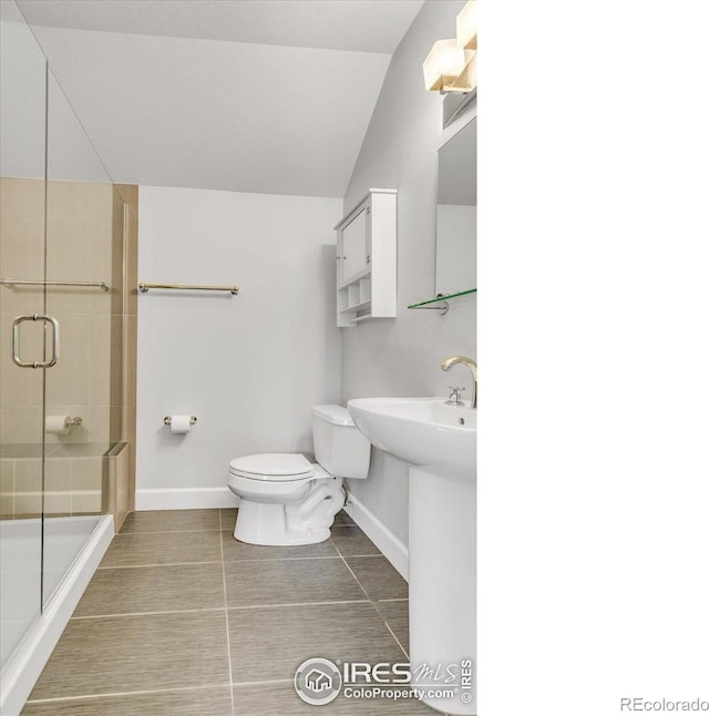 bathroom with an enclosed shower, toilet, and baseboards