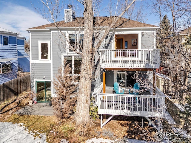 back of property with a patio, a chimney, a shingled roof, fence, and a deck