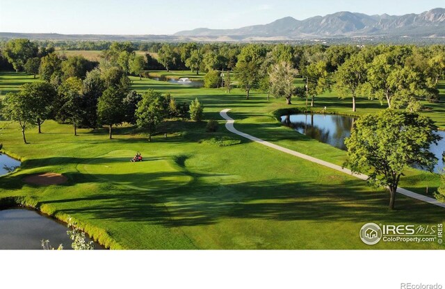 view of home's community featuring golf course view and a water and mountain view