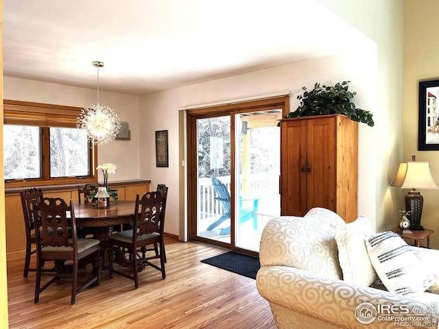 dining area featuring light wood-type flooring and a notable chandelier