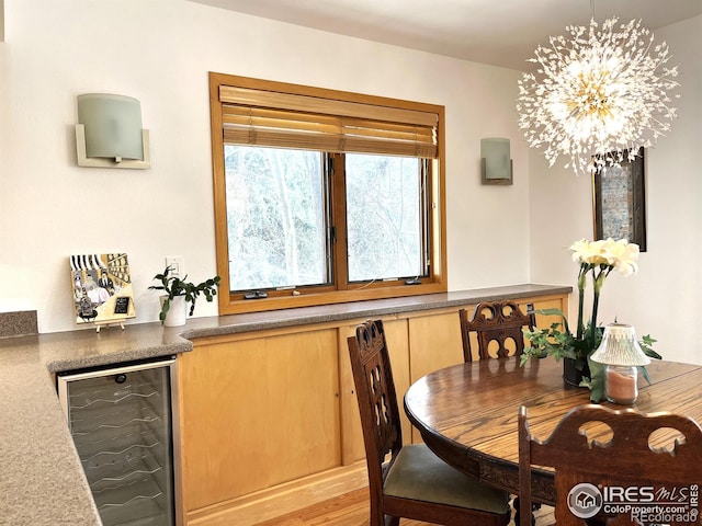 dining area featuring beverage cooler and an inviting chandelier