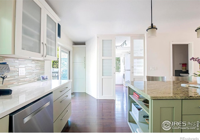 kitchen with backsplash, hanging light fixtures, stainless steel dishwasher, light stone counters, and green cabinetry