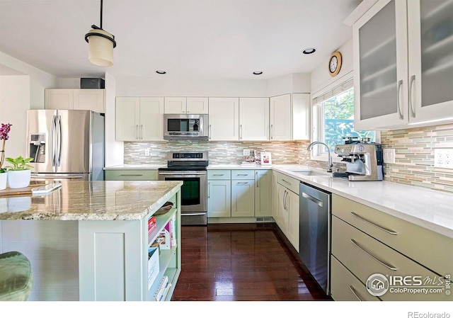 kitchen featuring sink, white cabinetry, decorative light fixtures, appliances with stainless steel finishes, and light stone countertops