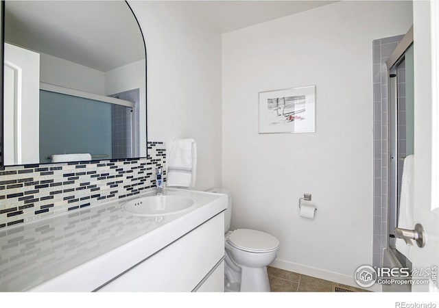 bathroom featuring tasteful backsplash, toilet, tile patterned flooring, and a shower with shower door