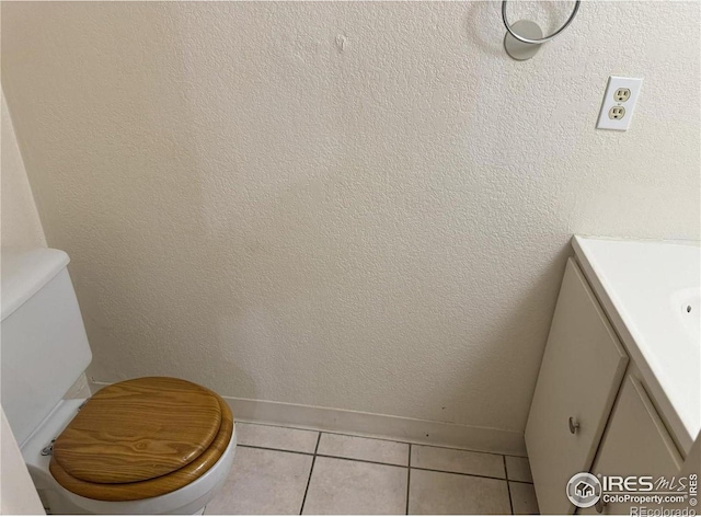 bathroom with tile patterned flooring, vanity, and toilet