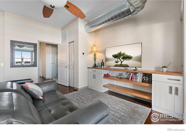 living room featuring ceiling fan and dark hardwood / wood-style floors