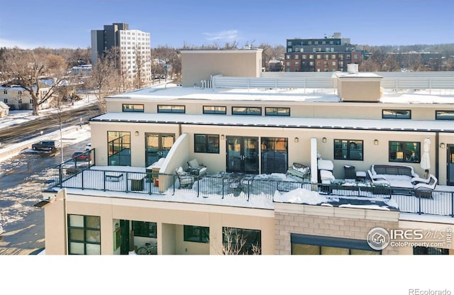 snow covered rear of property with outdoor lounge area