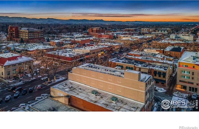 aerial view at dusk featuring a view of city and a mountain view