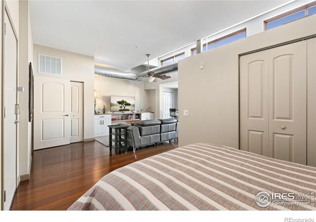 bedroom with a closet, visible vents, and dark wood-style flooring