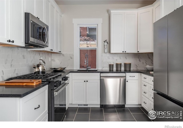 kitchen with stainless steel appliances, tasteful backsplash, sink, and white cabinets