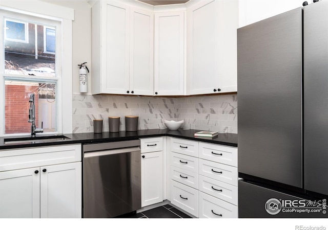 kitchen with white cabinetry, stainless steel appliances, sink, and decorative backsplash