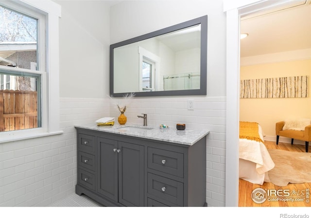 bathroom with tile walls, vanity, and hardwood / wood-style flooring